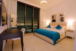 a bedroom with a bed and a desk and a window at Stunning Apartment with Direct access to Dubai Mall in Dubai