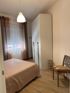 een slaapkamer met een bed, een stoel en een raam bij Gold sand in Cagliari