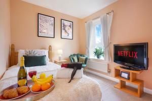 a bedroom with a bed with a tray of fruit and a television at Charming 4 Bedroom House in Prime Location - Close to City Centre - Free Parking, Smart TVs and Landscaped Garden by Yoko Property in Milton Keynes