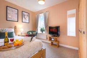 a bedroom with a bed with a tray of fruit and a television at Charming 4 Bedroom House in Prime Location - Close to City Centre - Free Parking, Smart TVs and Landscaped Garden by Yoko Property in Milton Keynes
