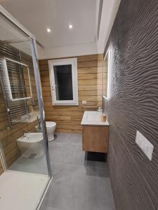 a bathroom with a shower and a sink and a toilet at Sirene452 - apartment - in Torvaianica