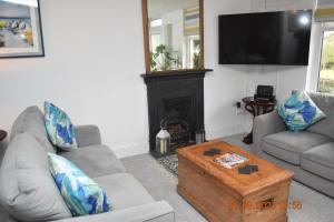 a living room with two couches and a tv at Ty Alban in Ffestiniog