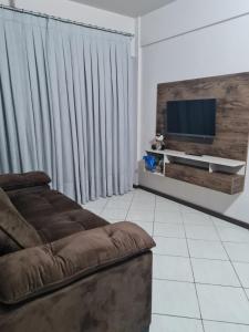sala de estar con sofá y TV de pantalla plana en Apartamento com mobília nova 201! en Francisco Beltrão