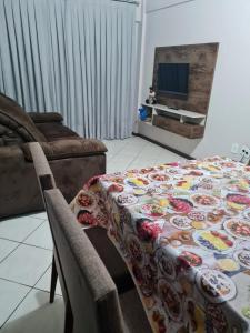 una sala de estar con una mesa con una manta. en Apartamento com mobília nova 201! en Francisco Beltrão