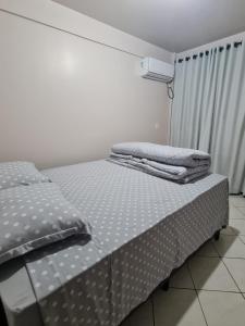 a bed in a room with two towels on it at Apartamento com mobília nova 201! in Francisco Beltrão