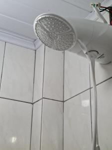 cabezal de ducha colgando del techo de una habitación en Apartamento com mobília nova 201! en Francisco Beltrão