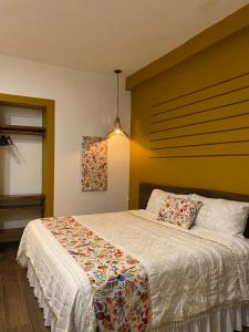 a bedroom with a bed with a white comforter at PASEO REAL HOTEL BOUTIQUE in Uruapan del Progreso