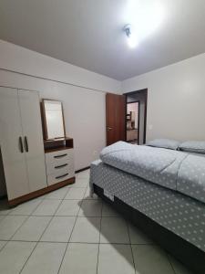 ein Schlafzimmer mit einem Bett, einer Kommode und einem TV in der Unterkunft Apartamento com mobília nova 201! in Francisco Beltrão