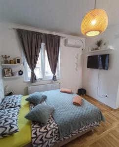 a bedroom with a bed with pillows and a television at Stan na dan Zvornik in Zvornik