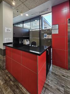 a kitchen with red cabinets and a black counter top at HOTEL MAUROS EL PUIG in El Puig