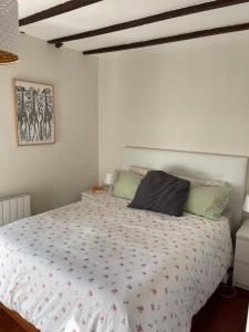 een slaapkamer met een bed met een wit dekbed bij Casuca Los Cencerros in Santander