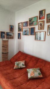 a bedroom with a large orange bed with pictures on the wall at aychik homestay in Ariana