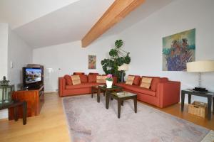 a living room with two red couches and a tv at Residenz Sonnwinkl in Reit im Winkl