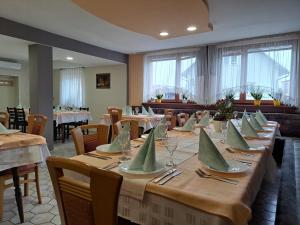 un comedor con una mesa larga con servilletas verdes. en Guesthouse Živko, en Dobrovce