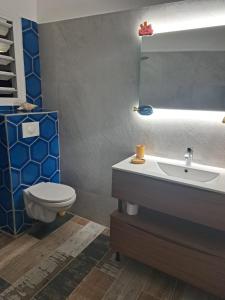 uma casa de banho com um WC, um lavatório e um espelho. em Bekeke em Capesterre
