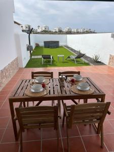 drewniany stół i krzesła na patio w obiekcie Casa Mic&ele w mieście Playa Blanca