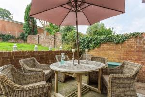 une table et des chaises en bois avec un parasol dans l'établissement 2 Elgin House, à Seaview