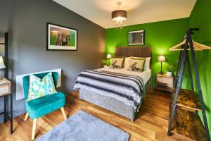 1 dormitorio con cama y pared verde en Host & Stay - Forest Green Lodge, en Alnwick