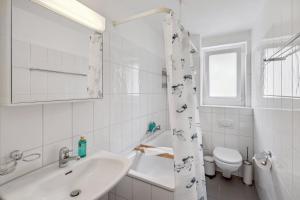 a white bathroom with a sink and a toilet at Dübendorfstrasse 171 in Zurich