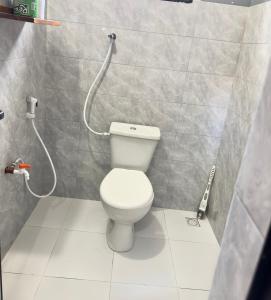 a bathroom with a toilet and a shower at Sally's home-near JNIA airport in Dar es Salaam