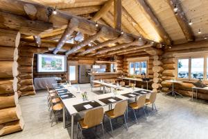 a dining room with tables and chairs in a log building at Hotel Kemmeriboden-Bad AG in Schangnau