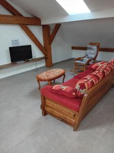 a room with a bed and a tv and a chair at La Bienvenue in Saint-Michel-sur-Meurthe
