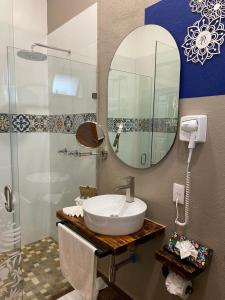 y baño con lavabo y espejo. en PASEO REAL HOTEL BOUTIQUE, en Uruapan del Progreso