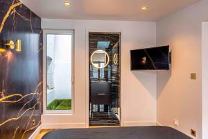 a room with a bed and a tv and a window at Orion in Trouville-sur-Mer
