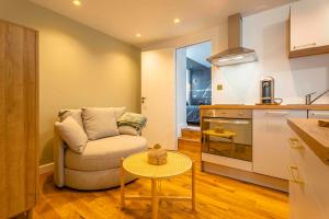a living room with a couch and a table in a kitchen at Orion in Trouville-sur-Mer