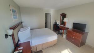 Dormitorio con cama, escritorio y TV en Clearwater Beach Hotel, en Clearwater Beach