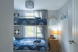 a bedroom with two bunk beds and a window at Driftwood - Charming family home in Deal