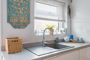 a kitchen counter with a sink and a window at Driftwood - Charming family home in Deal