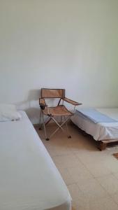 ein Bett und ein Stuhl in einem Zimmer in der Unterkunft aychik homestay in Ariana