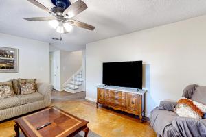 uma sala de estar com uma televisão de ecrã plano e um sofá em Towering Pines em Southaven