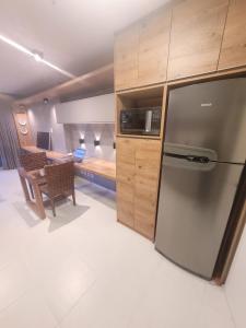 Vision Executive Premium Esplanada في برازيليا: مطبخ مع ثلاجة ستانلس ستيل وغرفة نوم
