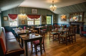 un restaurant avec des tables et des chaises et un lustre dans l'établissement George and Dragon Clifton, à Penrith