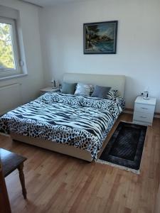 een slaapkamer met een bed met een cheetah deken bij Apartman Marica in Ilok