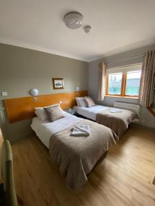 1 dormitorio con 2 camas y ventana en Gogartys Temple Bar Apartments, en Dublín