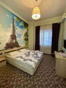 a bedroom with a bed and a painting of the eiffel tower at Elysian hotel in Astana