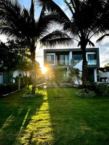 una casa con dos palmeras en un patio en Villa 81 Sanctuary Hồ Tràm Resort, built on Jun 2023 en Ho Tram