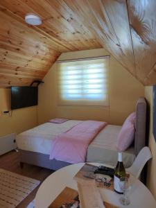 a bedroom with a bed and a table with a bottle of wine at Studio apartmani Anastasija in Žabljak