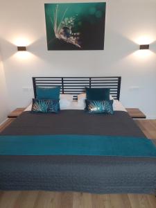 ein Schlafzimmer mit einem großen Bett mit blauen Kissen in der Unterkunft COMFORT Suites VELIKA GORICA in Velika Gorica