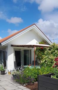 a white house with a patio and flowers at The Studio in Klövedal