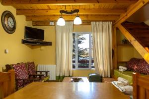 a living room with a table and a couch and a tv at Complejo Moquehue in Villa Pehuenia