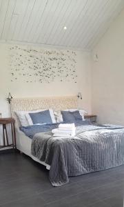 Un dormitorio con una cama grande con una pared con pájaros. en The Studio en Klövedal