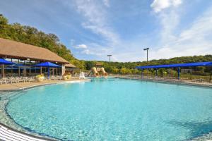 ein großer Pool in einem Resort mit blauen Sonnenschirmen in der Unterkunft Galena Getaway with Hot Tub, Home Theater and More! in Galena