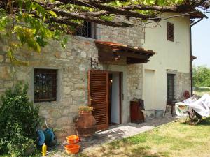 une maison en pierre avec une porte et une fenêtre dans l'établissement Pulica Holiday Home, à Barberino di Mugello
