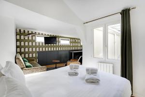 una camera con letto bianco e un soggiorno di Pick A Flat's Apartements in Louvre-Rivoli - Rue du Roule a Parigi