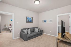 a living room with a couch and a flat screen tv at Oasis of Relaxation next to LSU perfect for groups in Baton Rouge