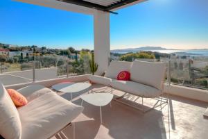 una sala de estar con muebles blancos y vistas al océano. en Prestigious villa with panoramic sea view, en Bandol